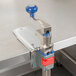 A metal table with an Edlund A932SP can opener base with a blue handle clamp.