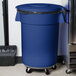 A blue Carlisle Bronco trash can lid on a blue trash can.