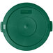 A green Carlisle Bronco lid for a round trash can with a small hole in it.