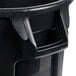 A black plastic Rubbermaid trash can with a handle.