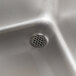 A close up of a drain in a APW Wyott stationary steam table.