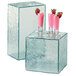 A Cal-Mil rectangular acrylic display riser with two glass cubes filled with pink drinks on top.