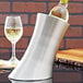 An American Metalcraft stainless steel wine cooler holding a bottle of wine on a table.