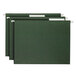 Three green file folders with Smead white tabs inserted into the clear tabs.