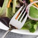 A Chef & Sommelier stainless steel salad fork on a plate of salad.
