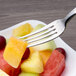 A Chef & Sommelier stainless steel dessert fork holding a piece of fruit on a plate.