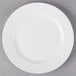 A 10 Strawberry Street Whittier white porcelain plate on a gray surface.