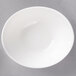 A 10 Strawberry Street Whittier white porcelain boat bowl on a gray surface.
