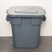 A Rubbermaid gray plastic square trash can with a lid.