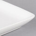 A close up of a 10 Strawberry Street rectangular white porcelain coupe platter with a small rim.