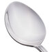 A close-up of a Libbey stainless steel serving spoon with a white handle.