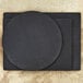 A dark slate Epicurean cutting board with a circle on top.