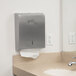 A white bathroom counter with a Lavex foaming hand soap dispenser and paper towel dispenser.