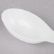 A white Fineline Tiny Tensils plastic spoon.