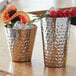 Two American Metalcraft hammered stainless steel tumblers filled with fruit.