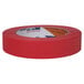 A roll of Duck Tape red masking tape with an orange stripe on the label.