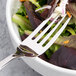 An Arcoroc stainless steel serving fork in a bowl of salad.