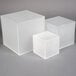 A set of three frosted acrylic cube risers stacked on top of each other.