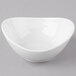 A Schonwald white porcelain dip dish with a small hole in the middle on a gray surface.