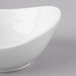 A close-up of a Schonwald white dip dish with a curved edge.
