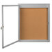 A cork board enclosed in a satin anodized frame with a glass door.
