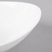 A close-up of a white Schonwald Grace bowl with a curved edge.