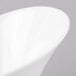 A close-up of a Schonwald Grace white porcelain Calla bowl with a curved edge.
