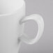 A close-up of a Schonwald white porcelain cup with a handle.