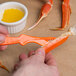 A person using a Choice Shuckaneer to peel a crab leg.