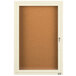 An ivory Aarco enclosed bulletin board cabinet with 1 door.