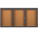 A brown rectangular Aarco bulletin board cabinet with three glass doors.