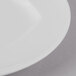 A close up of a Schonwald white porcelain plate with a white rim.