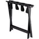 A black wood Lancaster Table & Seating folding luggage rack with straps.