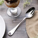A Chef & Sommelier stainless steel dessert spoon on a table with a glass of ice cream.