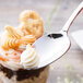 A Chef & Sommelier stainless steel dessert spoon with whipped cream on top.