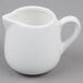 An American Metalcraft white porcelain creamer with a handle on a gray surface.