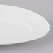A close-up of a Schonwald Grace Continental White Porcelain oval platter with curved edges.