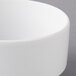 A close-up of a Schonwald white porcelain stacking bouillon cup.