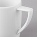 A close-up of a Schonwald white porcelain mug with a handle.