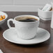 A Schonwald continental white porcelain cup of coffee on a table.