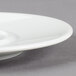 A Schonwald white porcelain saucer on a white plate.
