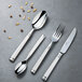 A Chef & Sommelier stainless steel dinner spoon on a table with other silverware.
