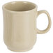 A beige coffee mug with a bulbous shape and speckled design on a white background.