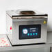 A VacPak-It VMC32 chamber vacuum packaging machine on a table with a screen and a gauge.