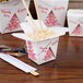A white Fold-Pak Chinese take-out container filled with food on a table with chopsticks.