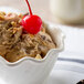 A Thunder Group San Marino dessert dish filled with ice cream topped with cherries and nuts.