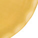 A yellow plate with gold pearl accents on a table.