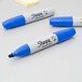 Three blue Sharpie chisel tip permanent markers.