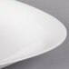 A close-up of a white oval porcelain plate with a thin stripe on it.