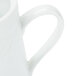 A close up of a white CAC porcelain creamer with a handle.